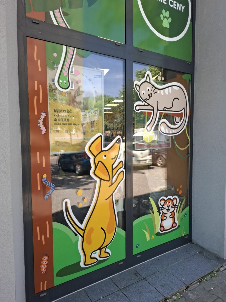 Folia reklamowa na witrynie sklepu zoologicznego z grafikami kota, psa i chomika